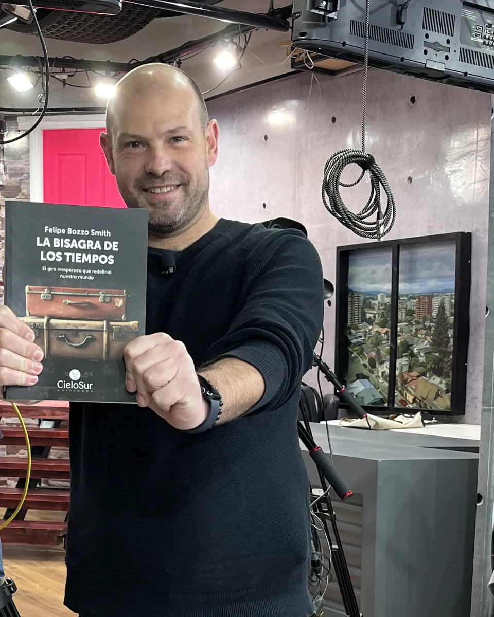 Felipe Bozzo, coach ejecutivo, con su libro La Bisagra de los Tiempos en un set de televisión